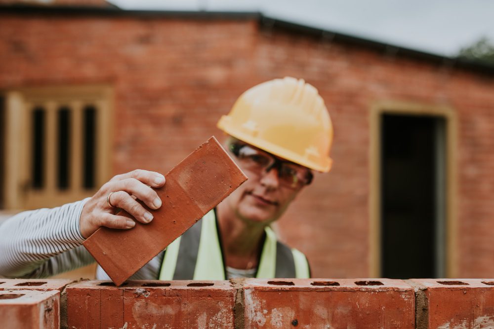 Woman contactor laying bricks outside the home Woman contactor laying bricks outside the home<br />